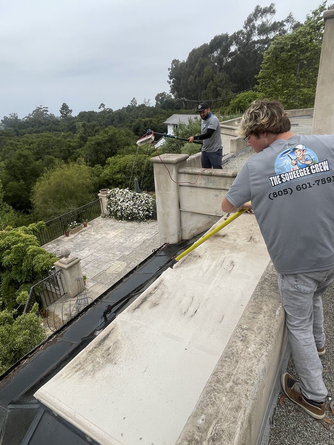 Squeegee Crew cleaning large glass windows with a water-fed pole in the 805