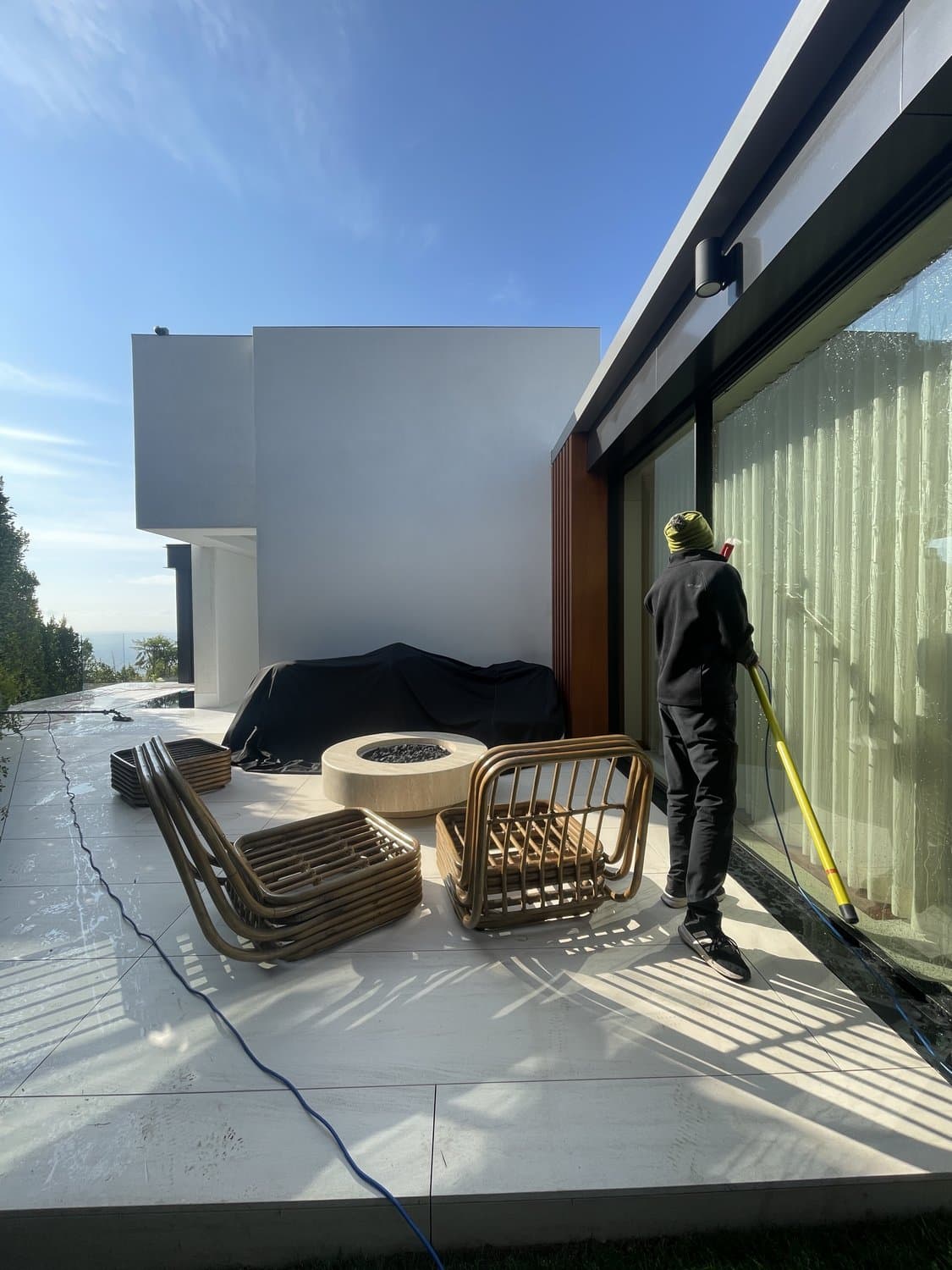 Squeegee Crew cleaning floor-to-ceiling glass at a modern hillside home in the 805