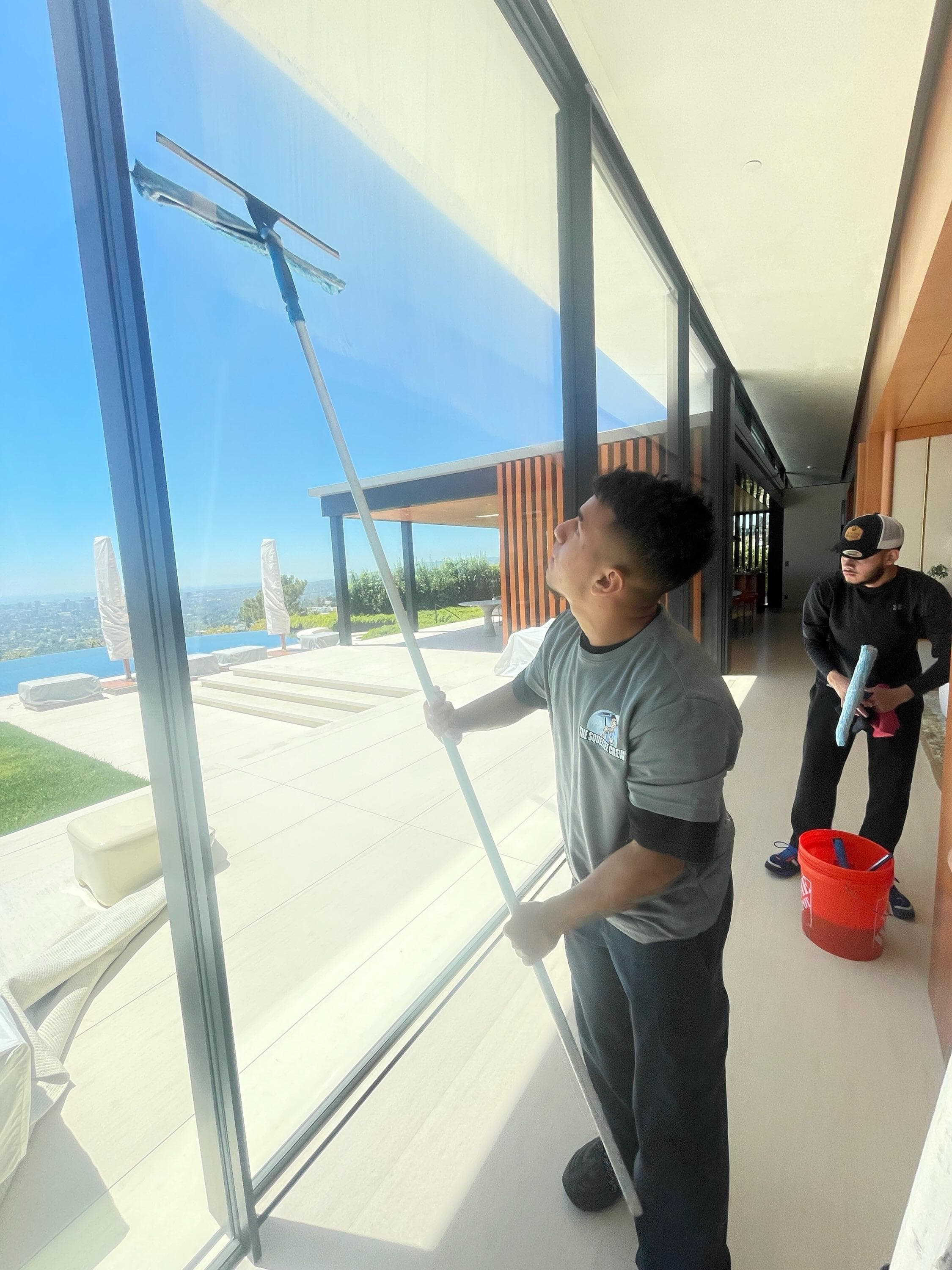 Squeegee Crew technician cleaning windows
